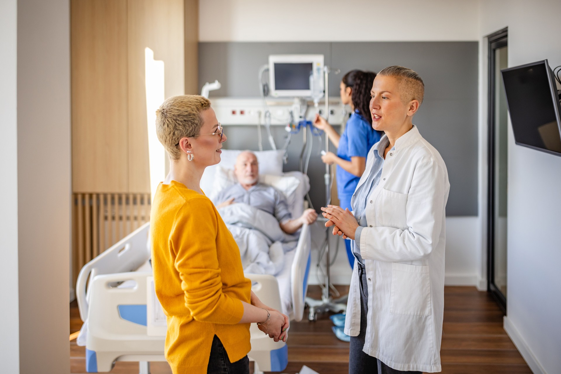 Senior man receiving care in hospital with healthcare professionals discussing treatment options